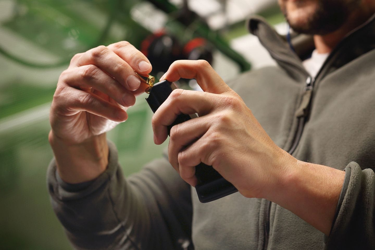 A person refilling an electronic cigarette device with e-liquid from a small bottle.