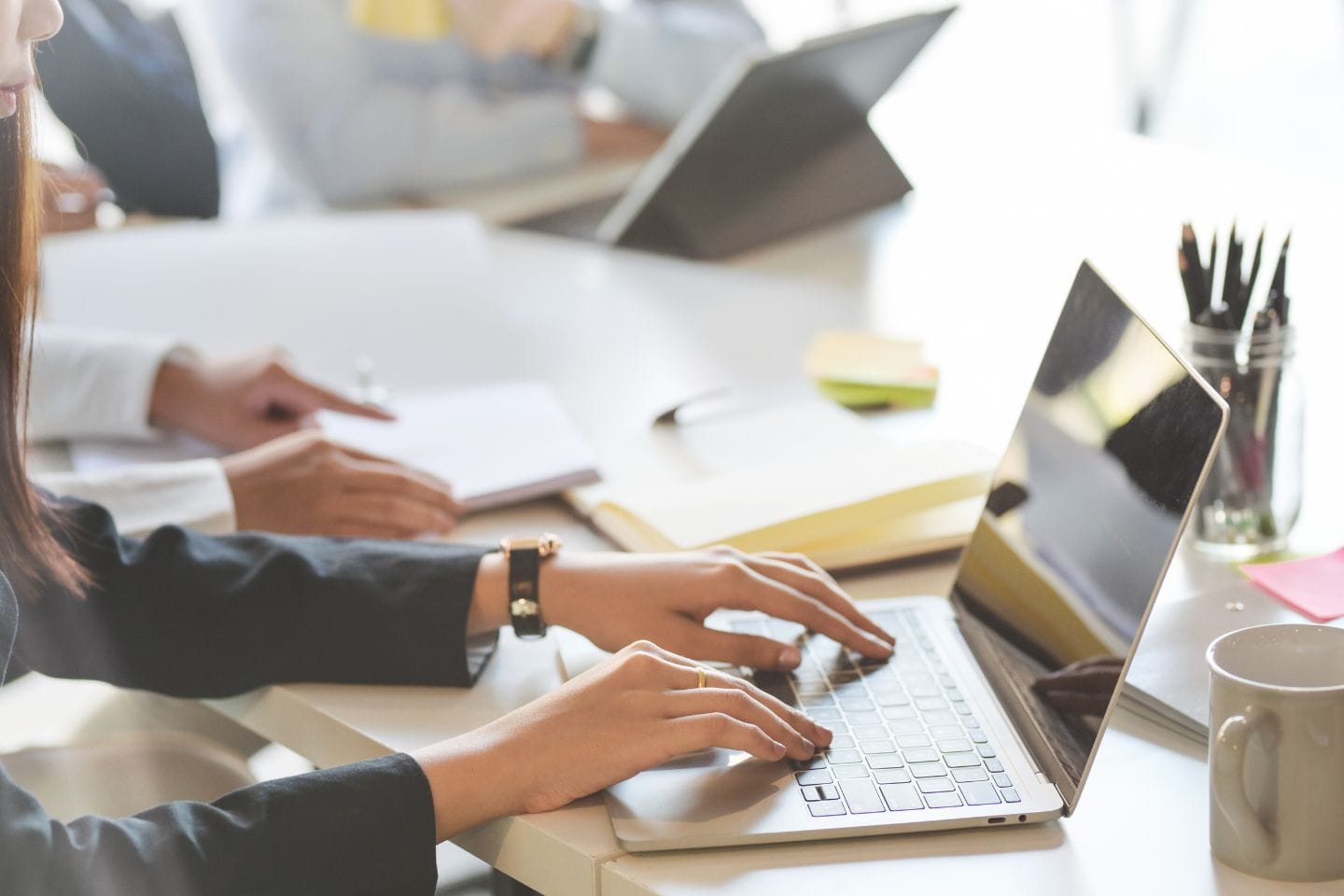 In a meeting room, people are focused on laptops and taking notes, diligently working as they delve into the nuances of corporate investigations.