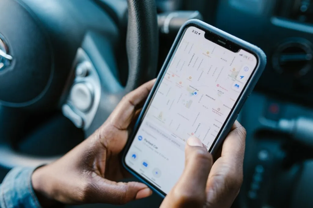 Identifying Issues With Your Current GPS Tracking System 6 Seated comfortably in the car, the person checks their smartphone with a map app open, utilizing the GPS tracking system to ensure accurate navigation.