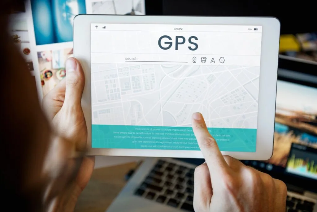 Identifying Issues With Your Current GPS Tracking System 9 A person holds a tablet featuring a GPS tracking system map interface, with various icons dotting the screen as their finger interacts with this dynamic display.